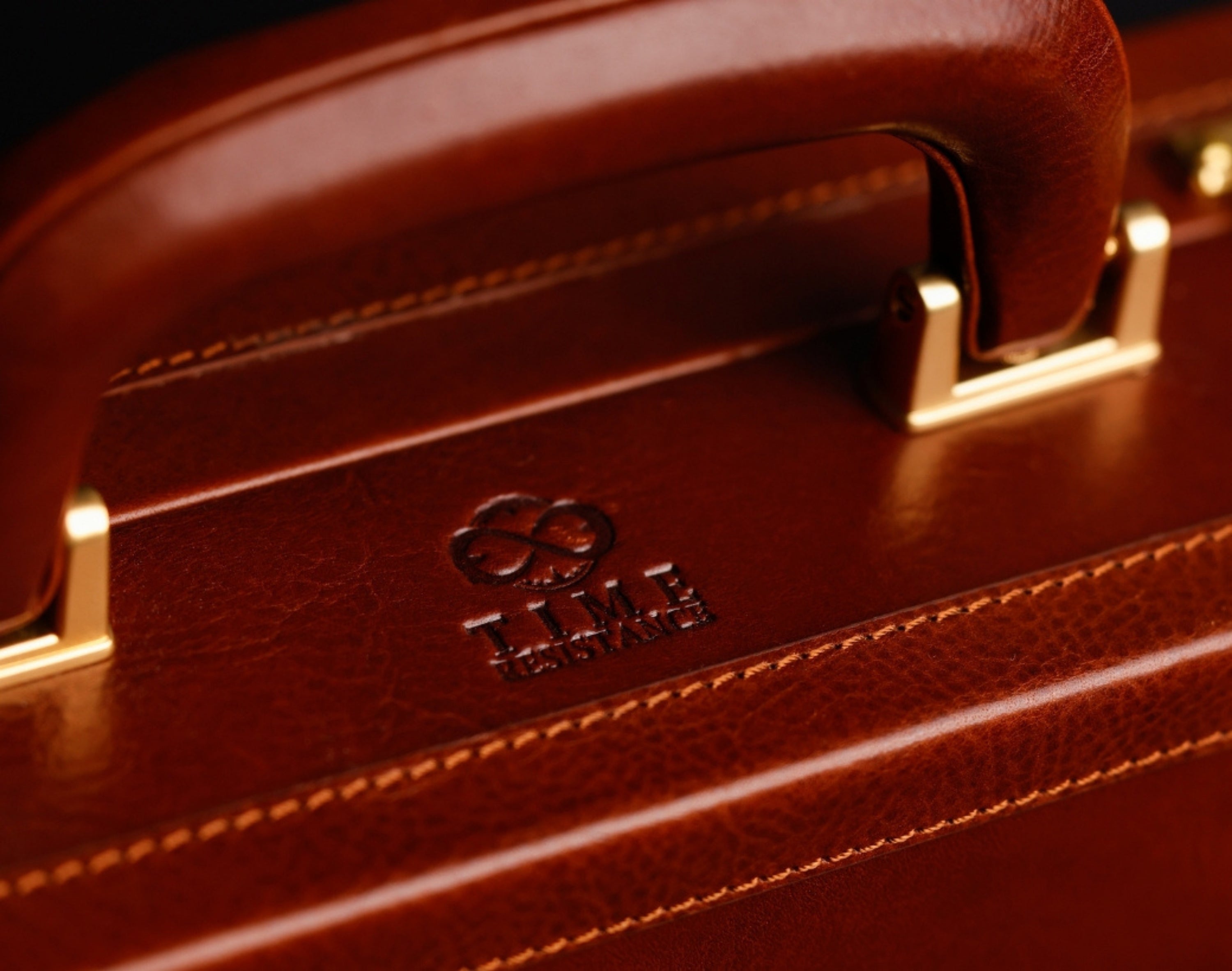 Leather briefcase handle with embossed Time Resistance logo