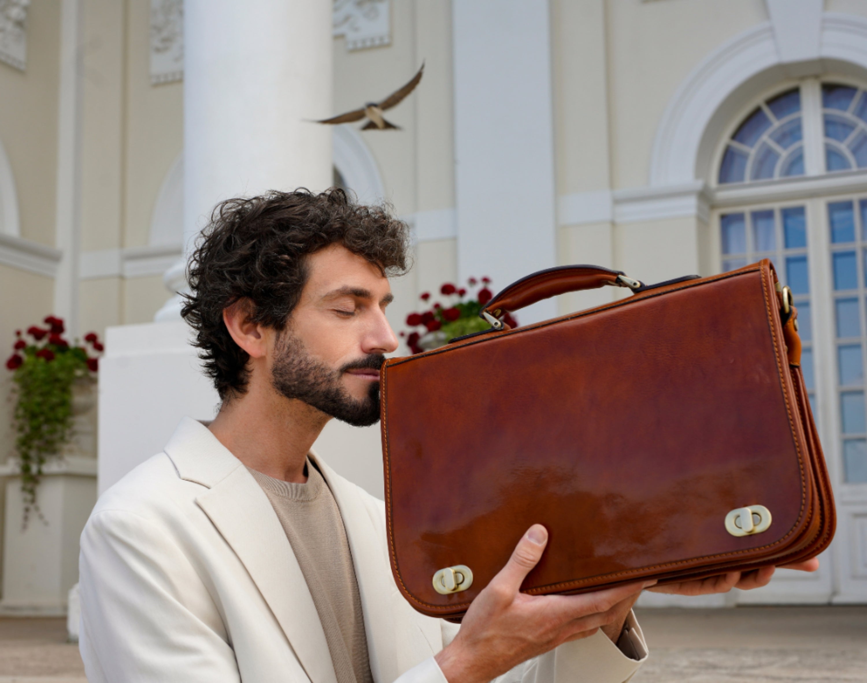 Man smelling a vegetable-tanned leather bag highlighting its natural scent and texture