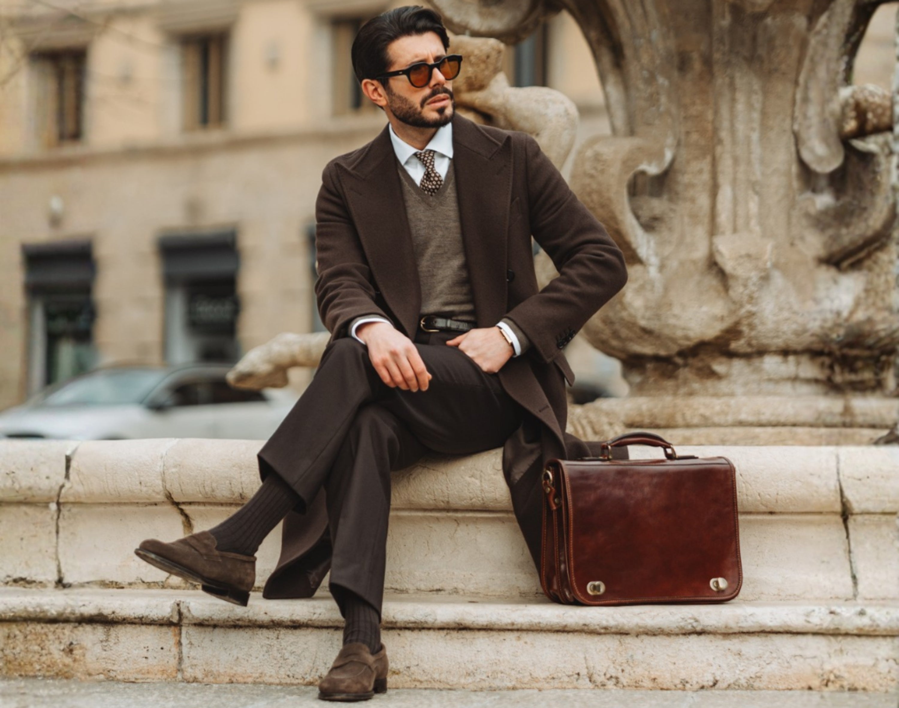 Man sitting with a leather briefcase beside him