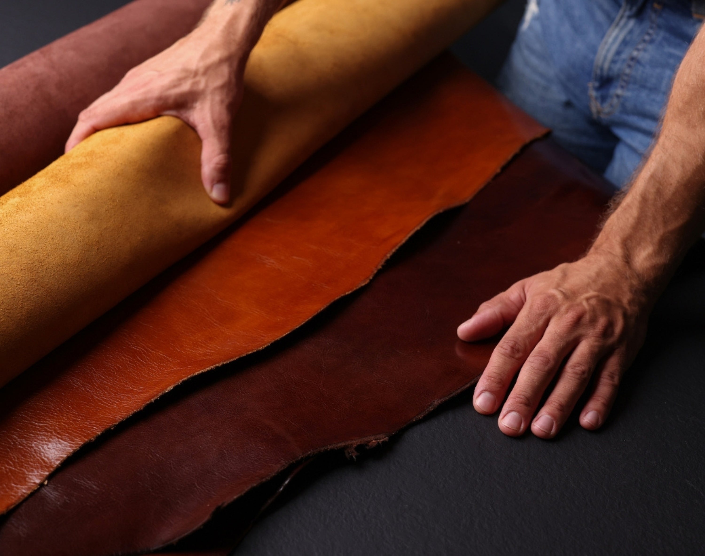 Man unrolling leather rolls in different colors